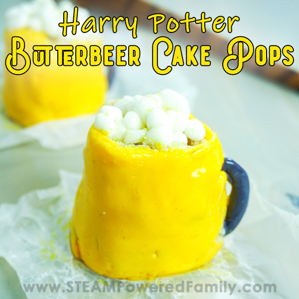 On a white background sits 2 cake pops shaped like butterbeer mugs with yellow bodies, white fluffy topping and grey handles. A wand lays in the back. Overlay text says Harry Potter Butterbeer Cake Pops
