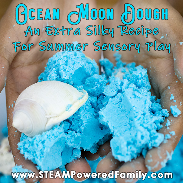 A child holds a handful of ocean blue moon dough with sea shells. Overlay text says Ocean Moon Dough An Extra Silky Recipe for Summer Sensory Play