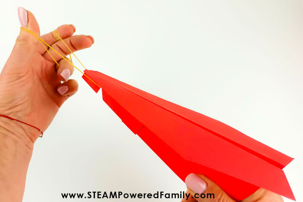 Paper airplane with elastic launcher