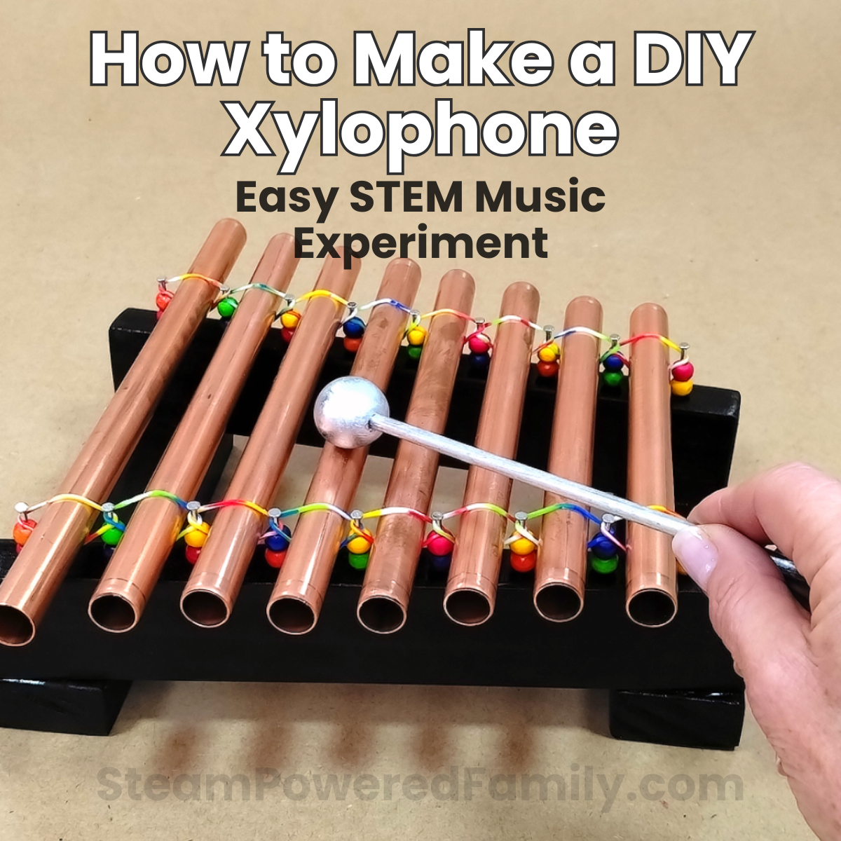 Finished DIY Xylophone made from copper pipes mounted on a painted wooden base, ready to play as a STEM music project for kids.